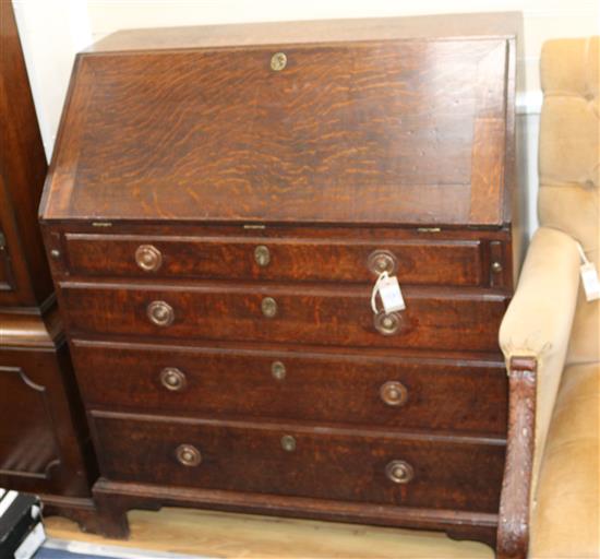 A George III oak bureau, with later handles W.94cm